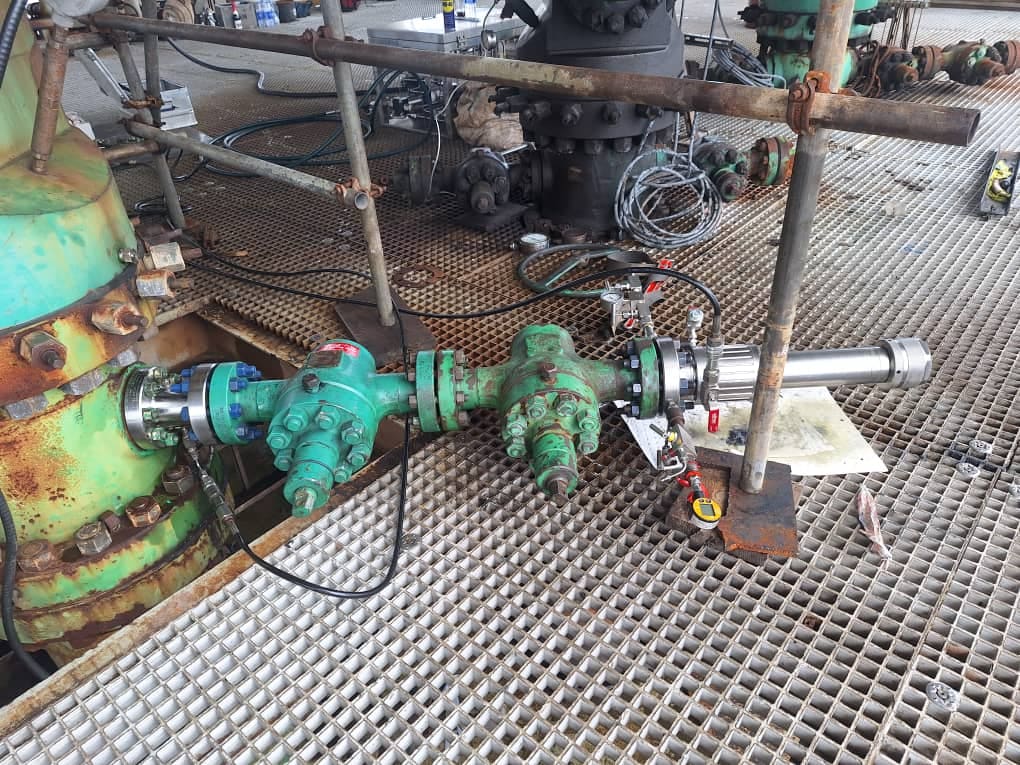 Close-up of a wellhead valve stack showing pressure-control fittings
