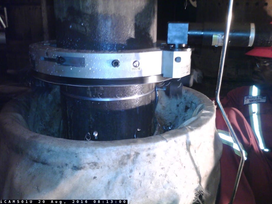 Cold cutting equipment clamped onto a wellhead riser during a controlled cut
